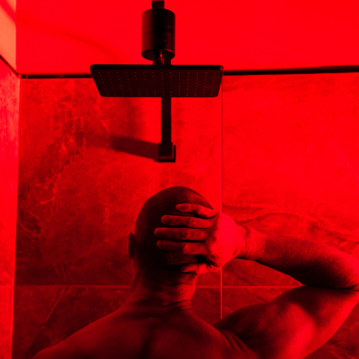 Black HUVE Flow Premium Shower Filter with male model with premium HUVE LUMA lighting for relaxation during the shower