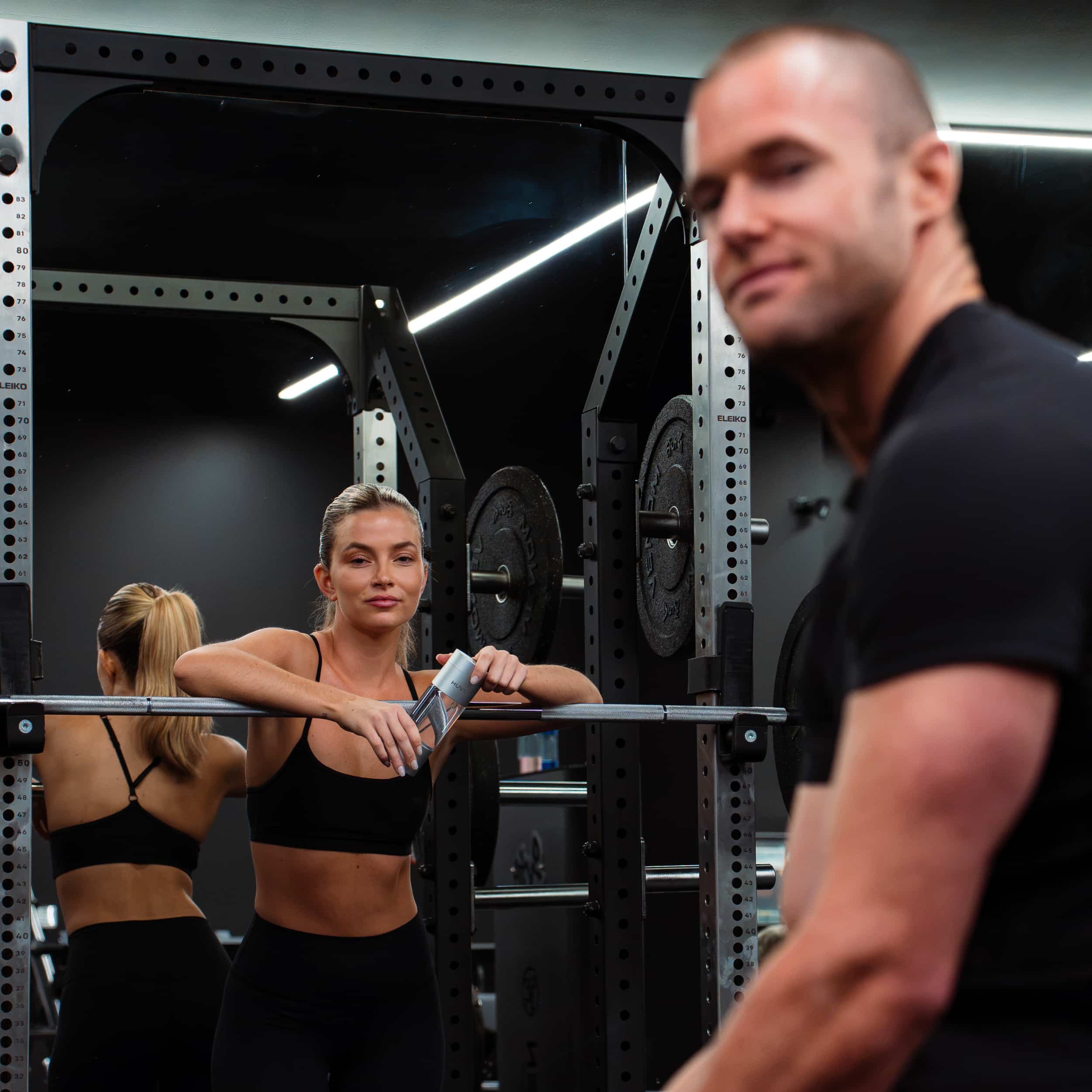 Couple training in a gym with a HUVE hydrogen water bottle