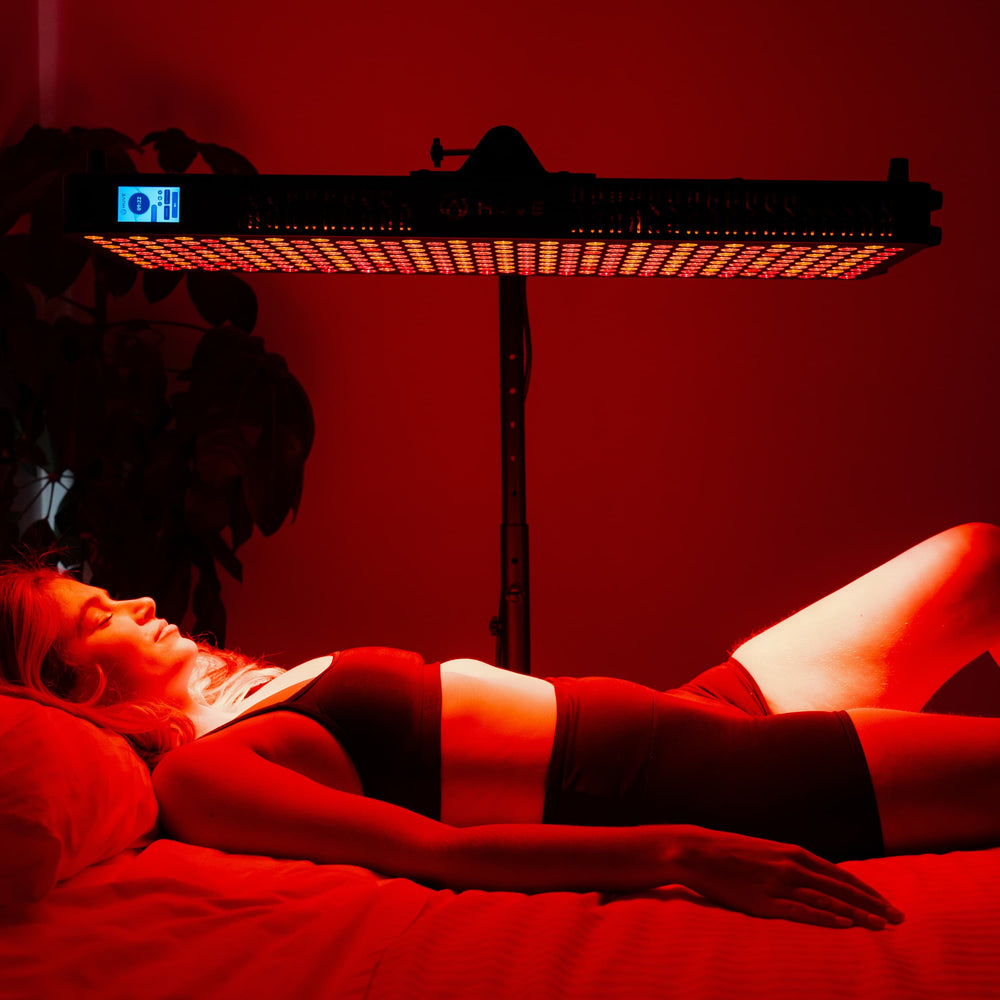 Woman lying under HUVE Luma red light therapy panel