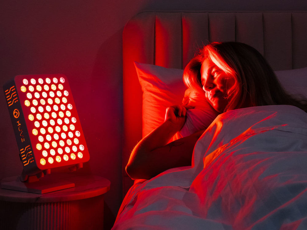 HUVE Luma red light therapy panel beside bed at night