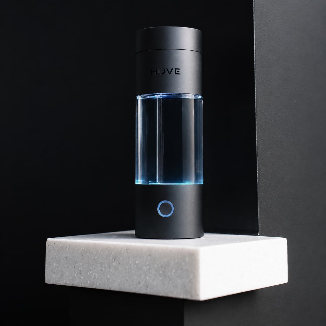 HUVE Perform hydrogen water bottle in matte black on a stone plinth